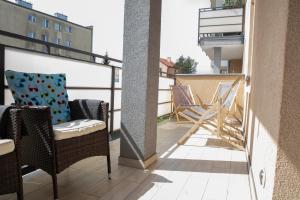 a balcony with chairs and tables on a building at Apartament Scandic in Malbork
