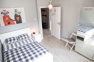 a white bedroom with a bed and a mirror at Apartament Scandic in Malbork