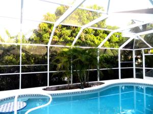 a swimming pool in front of a building at Mango Marco in Marco Island