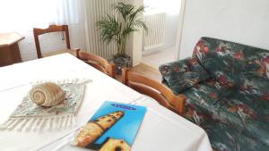 un soggiorno con tavolo, libro e divano di Casa Marietta a Caorle