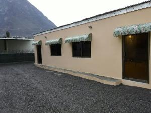 ein Gebäude mit Fenstern und einem Berg im Hintergrund in der Unterkunft Gilgit Deosai Executive Guest House in Gilgit