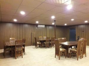 una sala da pranzo con tavoli e sedie in legno di Gilgit Deosai Executive Guest House a Gilgit