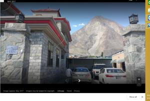 uma fotografia de uma montanha com carros estacionados numa rua em Gilgit Deosai Executive Guest House em Gilgit