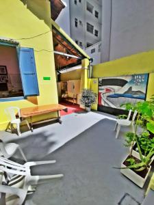 a patio with a bench and chairs in a building at Brasileranza Hostel in Niterói