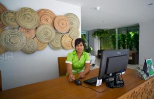 une femme assise sur un bureau avec un ordinateur dans l'établissement Nantra Chaweng Beach Hotel, à Chaweng