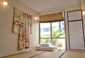 a room with a window with a bed in front of it at La Passione Boutique B&B in Naha