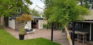 einen Hinterhof eines Hauses mit einer Terrasse in der Unterkunft Gastenverblijf Goudswaard in Goudswaard