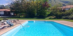 a blue swimming pool with a hose in a yard at Villa El tinganon in Llanes