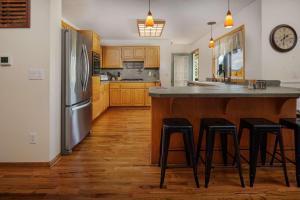 a kitchen with a stainless steel refrigerator and bar with stools at Pinot Vista in Dundee