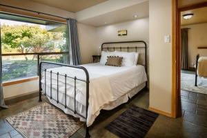 a bedroom with a bed and a large window at Pinot Vista in Dundee