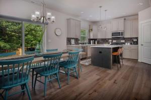 a kitchen with a table and chairs and a counter at Whispering Woods in Aloha