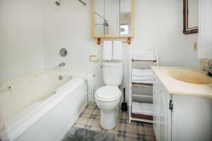 a bathroom with a toilet and a tub and a sink at Fernglen Forested Beach Retreat in Lincoln Beach +26 photos