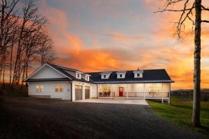 uma casa branca com um telhado preto em The Farmhouse at Quandary Vineyards em Carlton