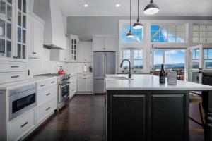 a kitchen with white cabinets and a large kitchen island at The Farmhouse at Quandary Vineyards in Carlton