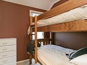 una camera con 2 letti a castello e un comò di Lochaber Lodge - Acacia Bay Holiday Home a Taupo