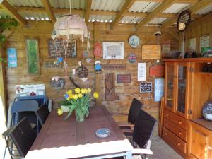 eine Holzhütte mit einem Holztisch, auf dem Blumen stehen in der Unterkunft Oddingsplace in Hardenberg