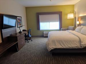 a hotel room with a bed and a flat screen tv at Holiday Inn Express Stephens City, an IHG Hotel in Stephens City