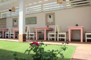a room with two tables and chairs and a lawn at Villamer Alaçatı in Alacati