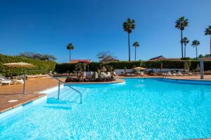 a swimming pool in a resort with palm trees at Sunny Villa Maspalomas in Maspalomas