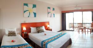 a hotel room with two beds and a balcony at Anchorage Beach Resort in Lautoka