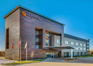 a hotel building with a sunilla sign on it at La Quinta Inn & Suites by Wyndham Lewisville in Lewisville
