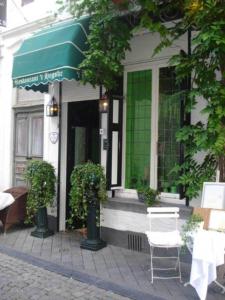 a building with a green awning and a table and chairs at Suite " Mon Rêve " in Maastricht