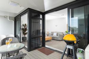 a living room with sliding glass doors and a table at Rooftop Retreat - Mount Maunganui Holiday Home in Mount Maunganui
