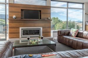 a living room with a couch and a fireplace at La Maison De Verre - Akaroa Holiday Home in Akaroa