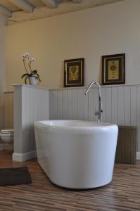 een groot wit bad in een badkamer met een toilet bij B&B 't Huys van Enaeme in Oudenaarde