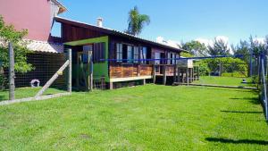 a house with a grass yard in front of it at Cigana's House 1 - Região do Farol de Santa Marta in Laguna