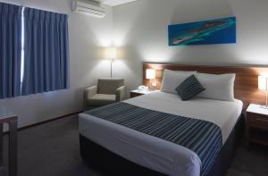 Ocean Centre Hotel في جيرالدتون: غرفه فندقيه بسرير وكرسي