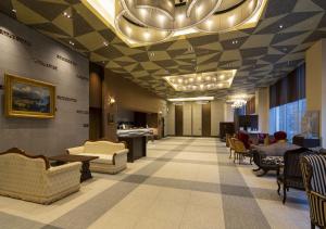 a lobby with a waiting area with chairs and tables at Hotel Monterey Fukuoka in Fukuoka