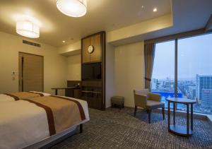 Hotel Monterey Fukuoka في فوكوكا: غرفة فندقية بسرير ونافذة كبيرة