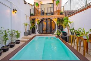 a swimming pool in the middle of a house with plants at Isara Boutique Hotel and Cafe in Phuket