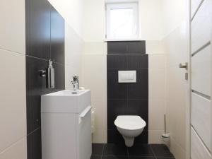 La salle de bains est pourvue de toilettes, d'un lavabo et d'une fenêtre. dans l'établissement Vila pod Majákem, à Přítluky