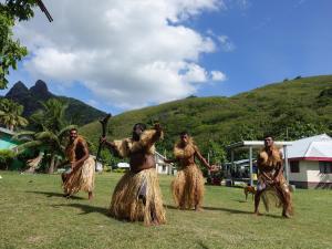 a group of people dancing in the grass at Octopus Resort in Nalauwaki
