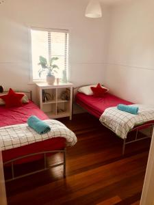 a bed room with two beds and a desk at Ella May Holiday Flats in Tuross Heads