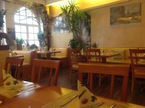 un restaurante con mesas y sillas de madera y un comedor en Pension Da Gigi, en Oschersleben