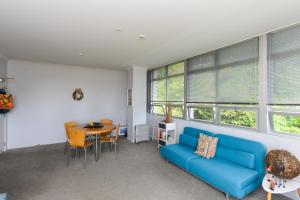 a living room with a blue couch and a table at Napier Inner City Apartment - Napier Apartment in Napier