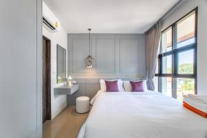 a bedroom with a large white bed with pink pillows at 2BDR Apartment near Surin beach #703 in Surin Beach +22 photos