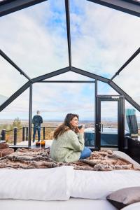 a woman sitting on a bed in a room with a view at Golden Crown - Levin Iglut in Levi