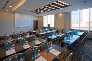 a conference room with tables and chairs and a screen at Crowne Plaza Istanbul Oryapark by IHG in Istanbul +37 photos