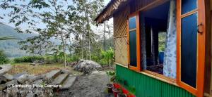 a house with a window and a mountain in the background at Sampang Homestay in Mangpu