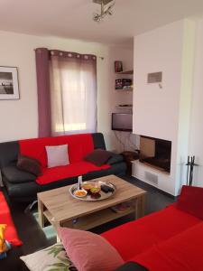 a living room with a red couch and a coffee table at Holiday House Tereza in Lipno nad Vltavou