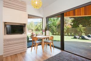 a dining room with a table and chairs and a large window at The Kite - Abel Tasman in Marahau