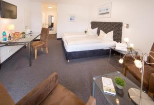 Una habitación de hotel con una cama y una sala de estar. en Hotel Am Kurpark Späth, en Bad Windsheim 43 fotos más