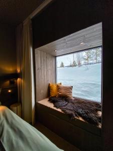 a window seat in a room with a view of snow at Bjørnfjell Mountain Lodge in Alta