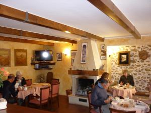 a group of people sitting at tables in a restaurant at Garnì B&B La Rua-Pescocostanzo in Pescocostanzo