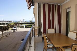 a balcony with a table and chairs and a view of the beach at AT031 Comunidad con 2 piscinas, a 5 min a pie de la playa in Torredembarra