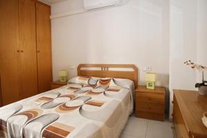 a bedroom with a bed with slippers on it at AT031 Comunidad con 2 piscinas, a 5 min a pie de la playa in Torredembarra +12 photos